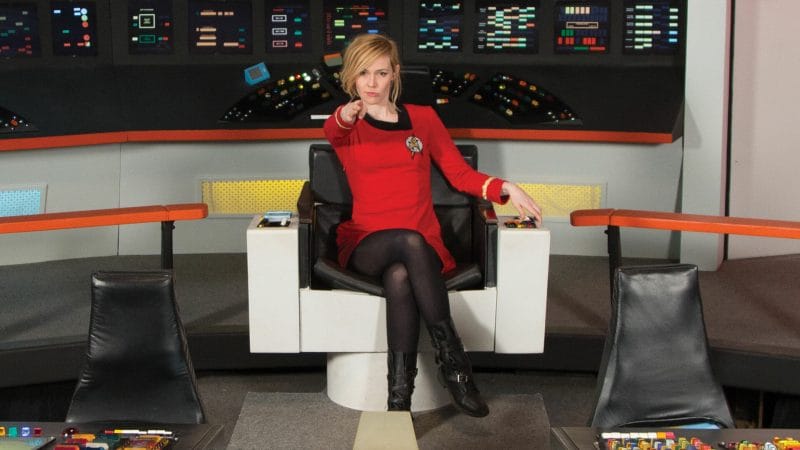 A woman in a red dress sitting in a chair appears in a Star Trek fan film produced by Potemkin Pictures.