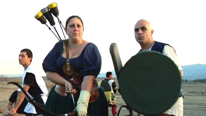 A group of people dressed in medieval clothing and holding bows and arrows.