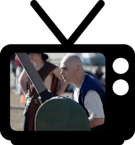 A man holding a sword in front of a tv.