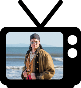 A man in a pirate costume standing in front of a television.