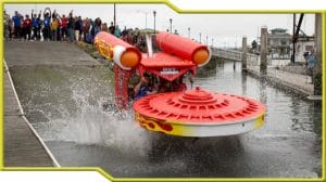 A red and yellow boat participating in the Kinetic Grand Championship, a human-powered art race.