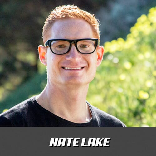 Nate lake is smiling in front of a grassy field.