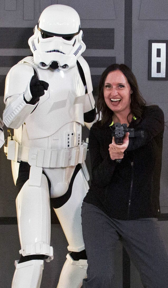 A woman posing next to a stormtrooper.