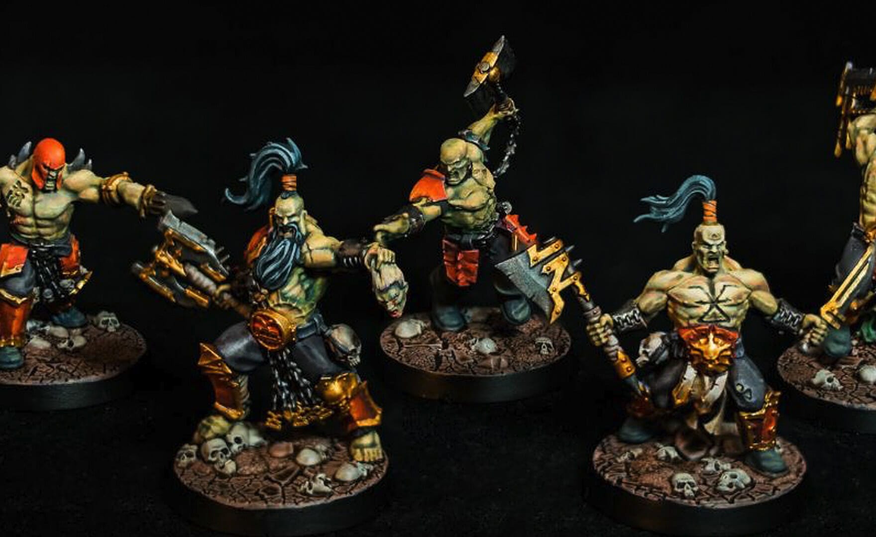 A group of painted warhammer miniatures on a black background, showcasing miniature painting skills.