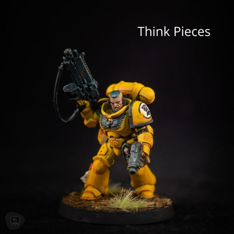 A yellow space marine wielding a gun and painted with expert precision for the world of Wargame Modeling.