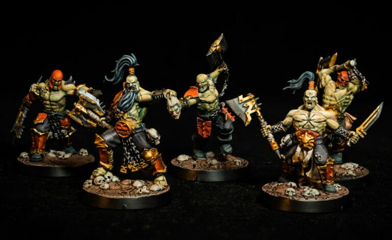 A group of painted warhammer miniatures on a black background showcasing exquisite miniature painting.