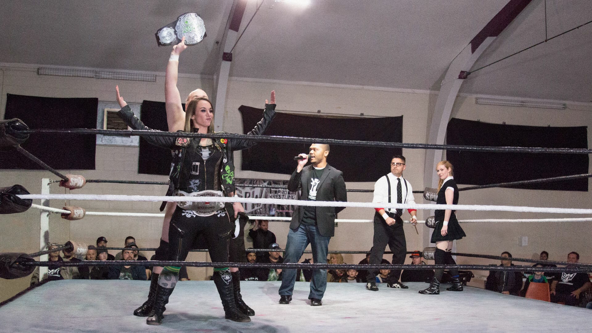 A group of professional wrestlers in a wrestling ring showcasing pro wrestling history.