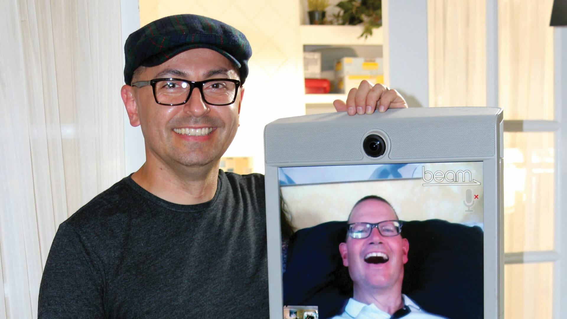A man holding up a tv screen with a picture of himself on it at the de Young Museum.