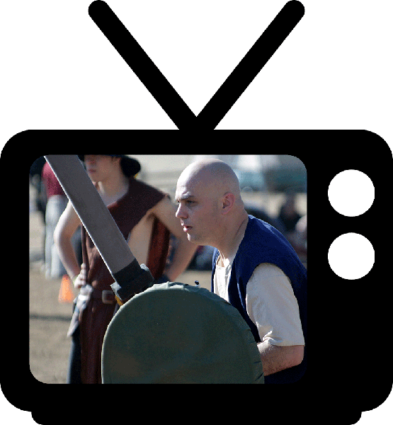 A man holding a sword in front of a tv.