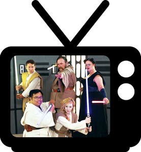 A group of people with star wars lightsabers in front of a television.