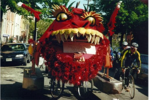 A red dragon on a bicycle.