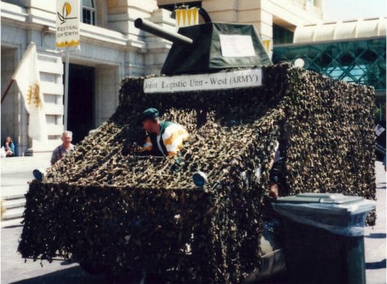 A man in a camouflaged vehicle.