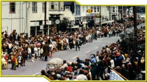 A crowd of people standing in a street at the Human-powered Art Race.