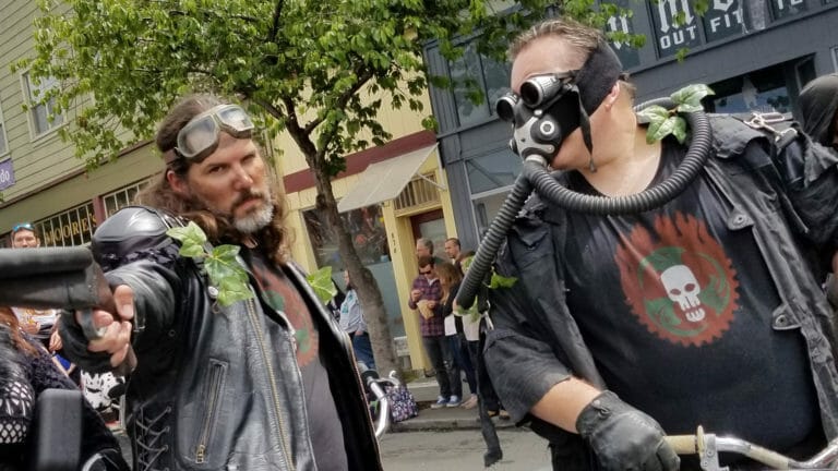 Two men on a motorcycle dressed in leather and gas masks participate in the Kinetic Sculpture Race.