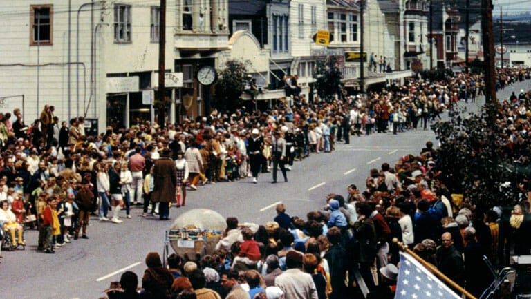 A crowd of people standing in a street.
