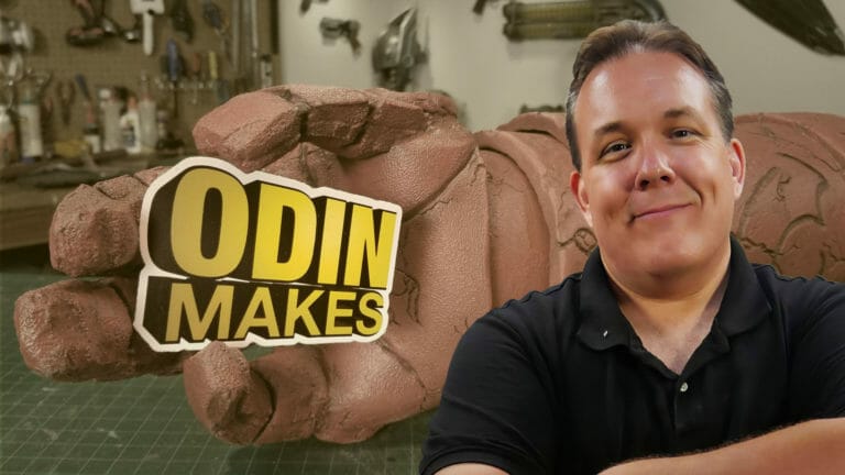 A man standing in front of a sign that says Odin Makes Mandalorian.